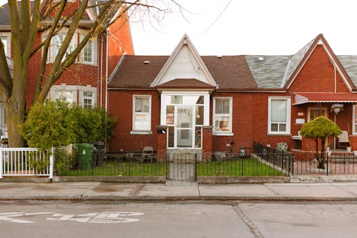 Old house facade with lawn near road