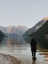 在奥地利哈尔施塔特宁静的湖边，一个人站在雄伟的群山之间
