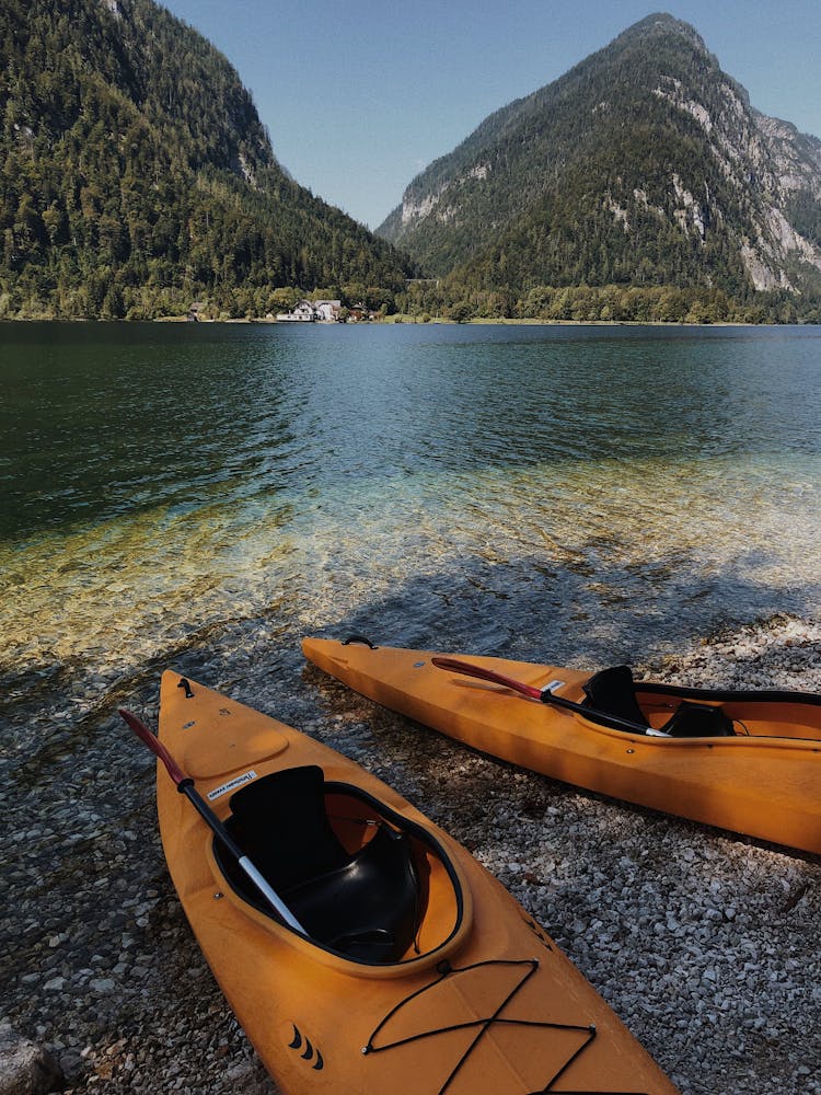 Yellow Kayaks On Shore Near Body Of Water