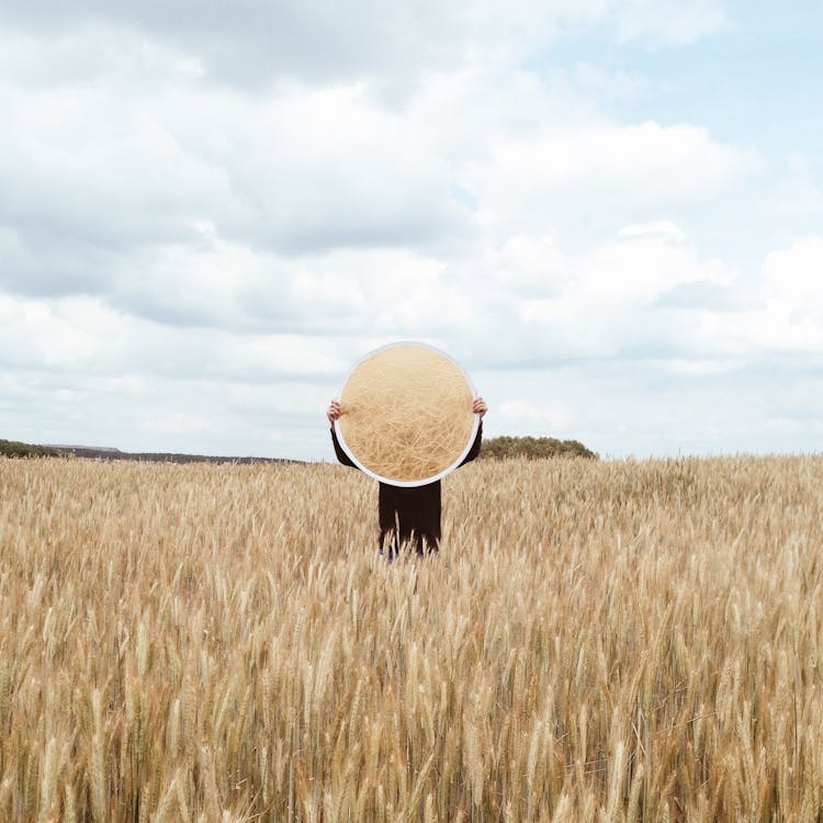 Free Person Holding a Mirror on an Open Field Stock Photo