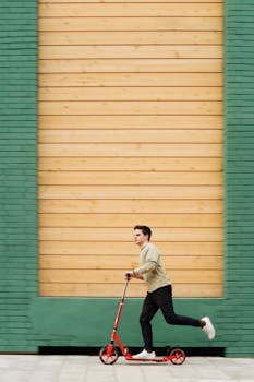 在现代城市的背景下，一名男子骑着红色踏板车，展现出充满活力的生活方式