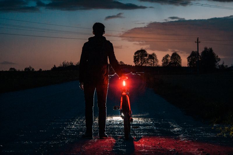 Radfahrer in der Dämmerung mit rotem Rücklicht