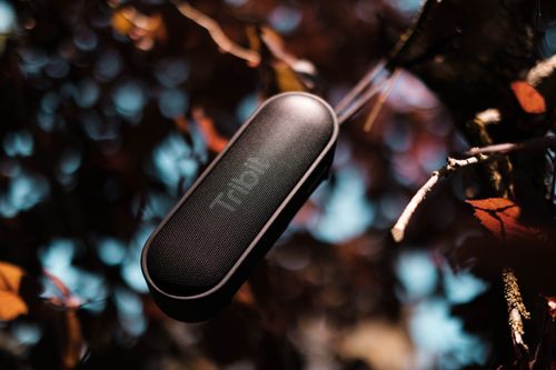 Free From above of contemporary design wireless speaker with shiny black surface on glass in evening Stock Photo