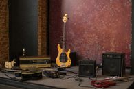 S type electric guitar placed on stage near various musical instruments and loudspeakers in shabby studio