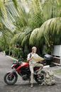 Focused man studying map leaning on motorbike
