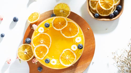 Orange Cheese Cake With Fresh Oranges and Blueberries on Wooden Board