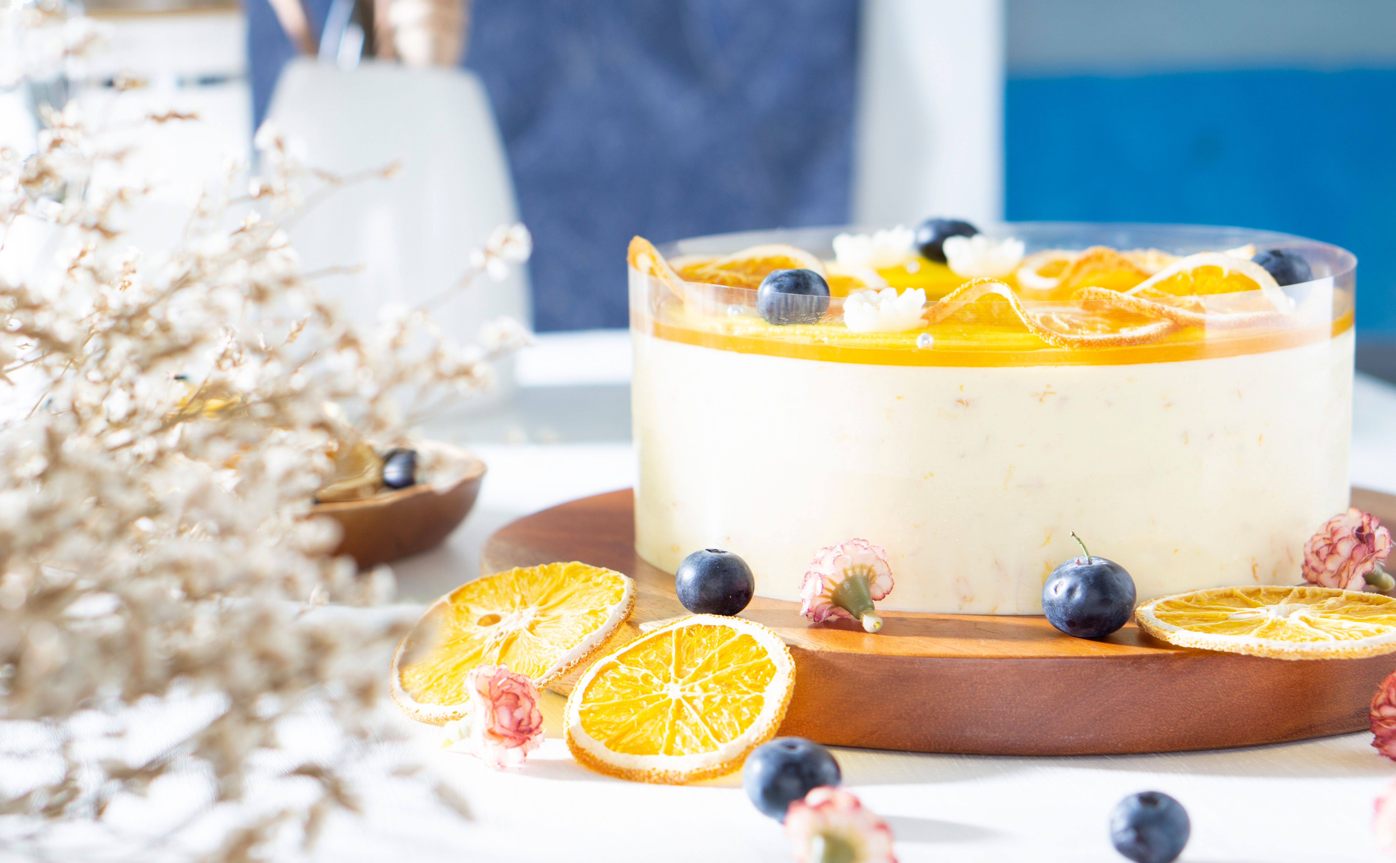 Mouthwatering orange cheesecake topped with blueberries and dried oranges, perfect for dessert lovers.