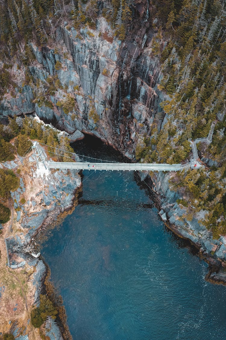 Bridge Over River Near Rough Terrain With Forest