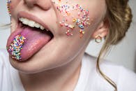 这是一张有趣的脸部特写，脸颊和舌头上布满充满活力的斑点，呈现出多彩而有趣的外观