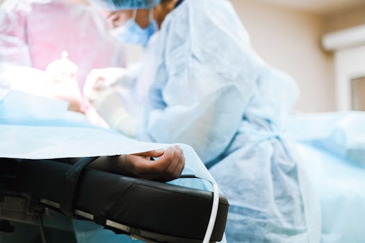 Surgeons in blue gowns performing a surgical procedure in a hospital operating room.