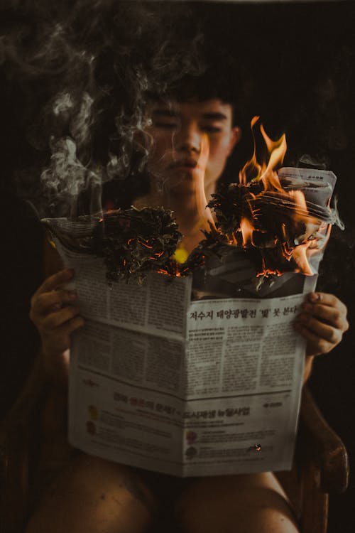 Man Holding Burning Paper