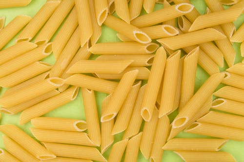 Close-Up Shot of Uncooked Pasta on Green Surface
