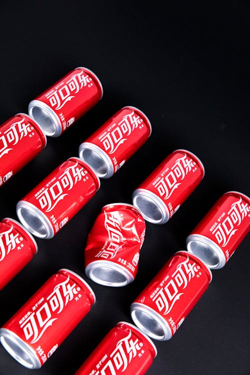 Free From above of red metal cans of fizzy cola placed on black table Stock Photo