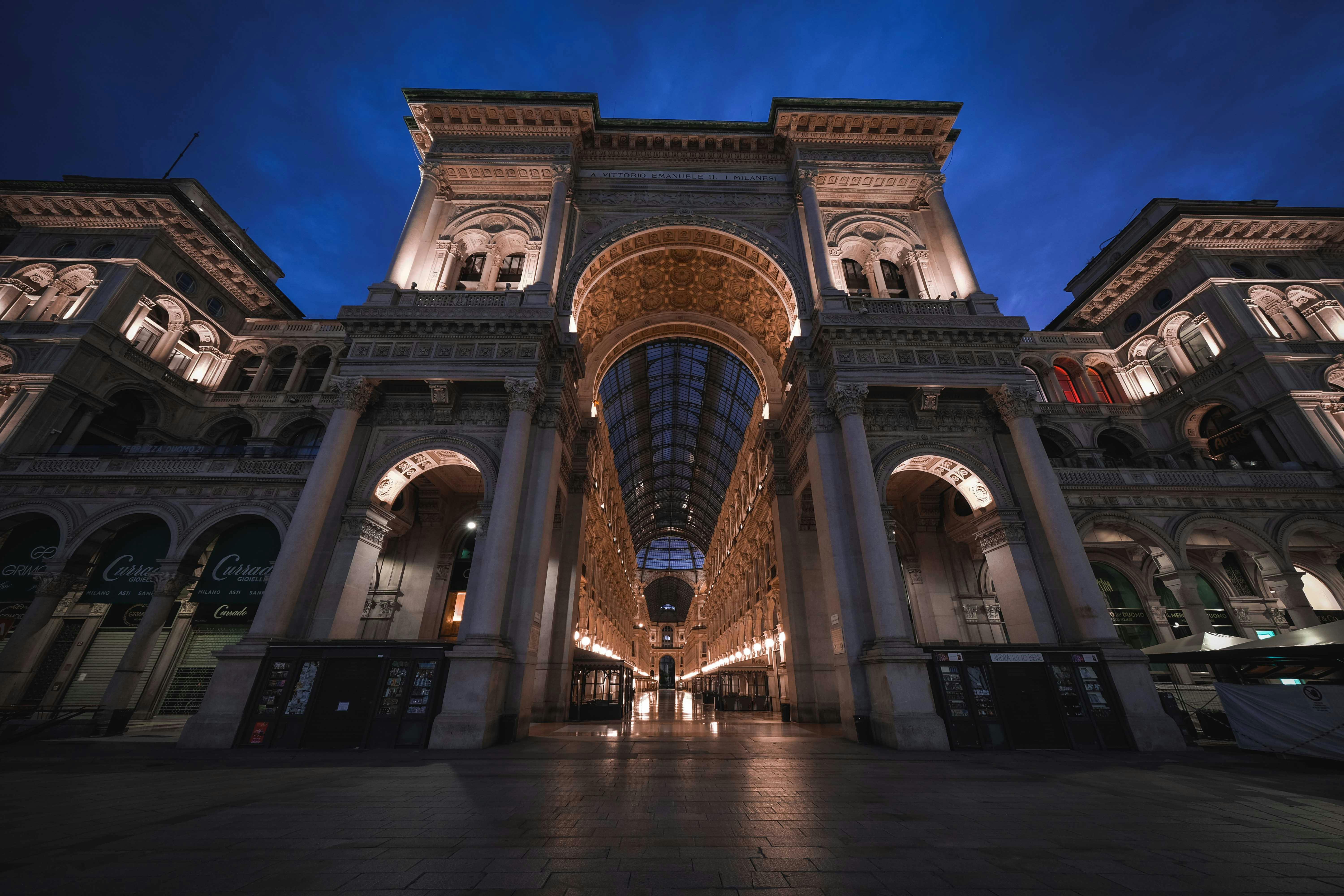 historical building with glass ceiling and arched passage in evening