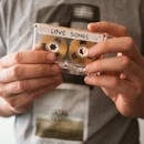 特写镜头捕捉到手持“情歌”复古磁带的怀旧氛围