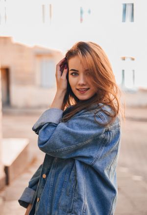 Woman in denim jacket over floral midi dress