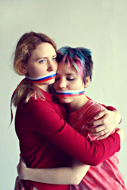Free Lesbian couple hugging with ribbon on mouths Stock Photo