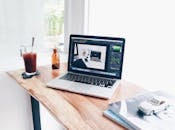 家庭办公室布置得很舒适，木桌上放着笔记本电脑和一杯冰咖啡