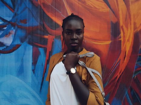 Young ethnic woman near graffiti wall