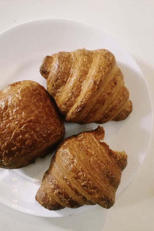 Delicious fresh croissants on white plate