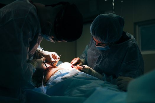 Plastic Surgeons Stitching Up a Woman's Augmented Breast