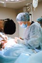 Man in White Scrub Suit Holding Baby