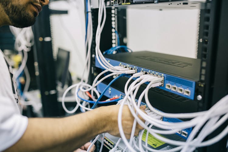 Electronics Engineer Fixing Cables On Server