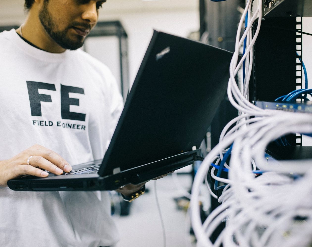 Field technology specialist working with network equipment and a laptop