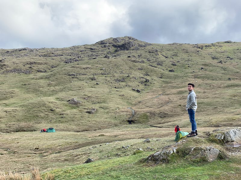 Detailopname van een hand die een houten tafelblad afwerkt met olie