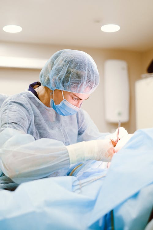 A Woman Wearing Personal Protective Equipment Holding Medical Apparatus