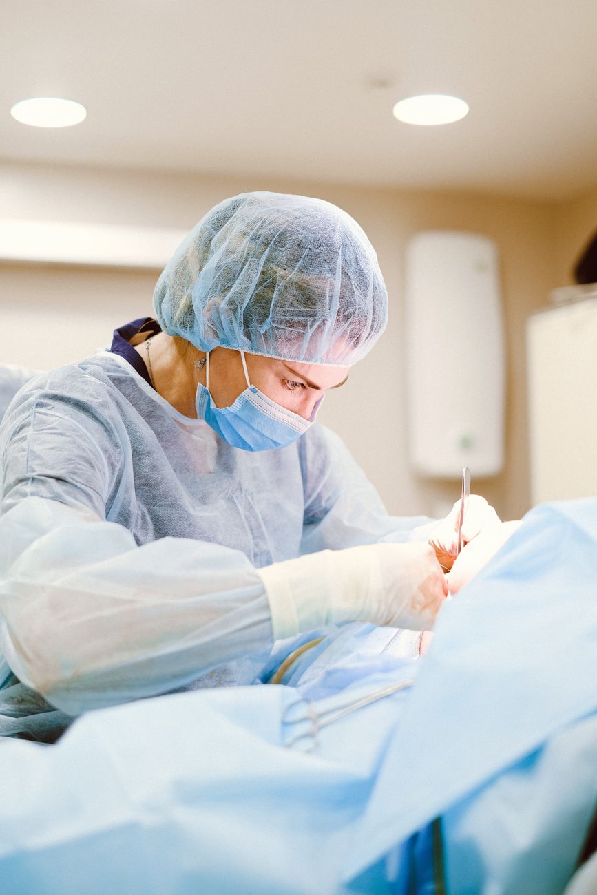 Un chirurgien expérimenté en tenue stérile réalise une intervention médicale dans un bloc opératoire.