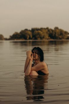 一个头发湿漉漉的女人，在宁静的湖水中享受着安宁，水面映照出一丝静谧