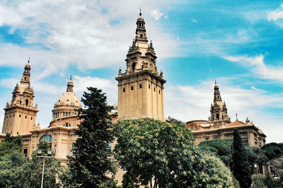 Arquitectura histórica del Museo Nacional de Arte de Cataluña en Barcelona bajo un cielo azul brillante.