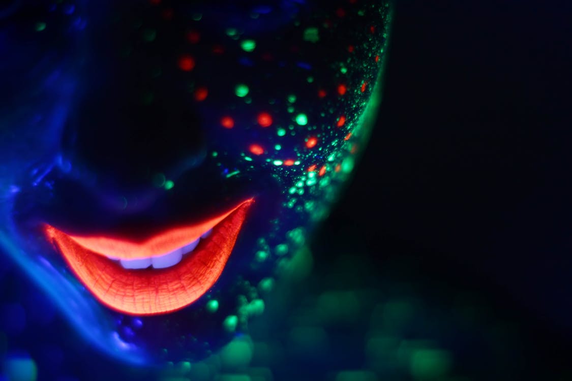 Smiling Fluorescent Face with Red Lips and Colored Dots