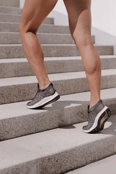 Dynamic shot of athletic legs in sneakers climbing stairs, perfect for fitness and lifestyle themes.
