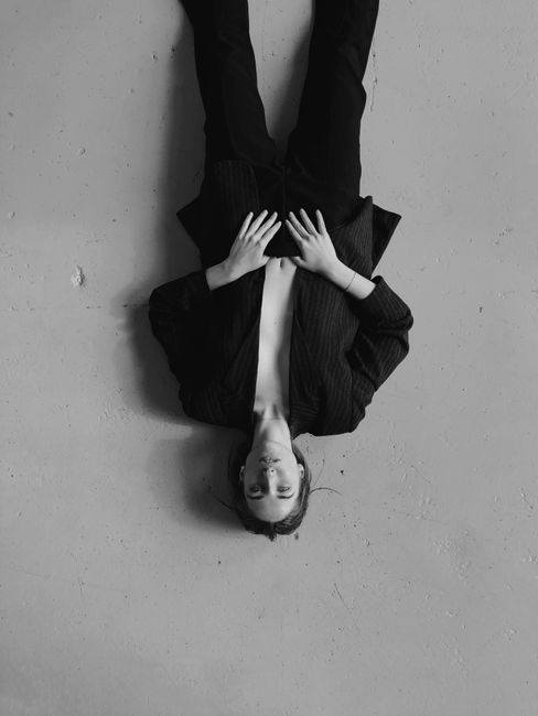 Upside-down portrait of a woman in a blazer, creating a unique artistic look.