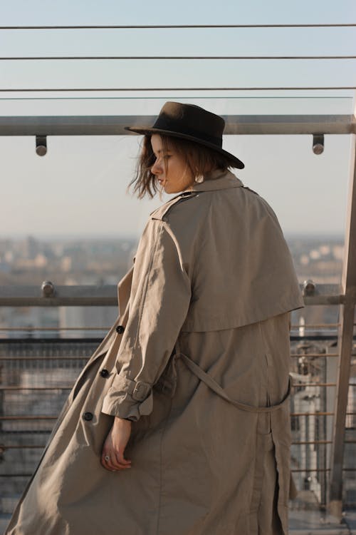 A Woman Wearing a Trench Coat and a Fedora Hat