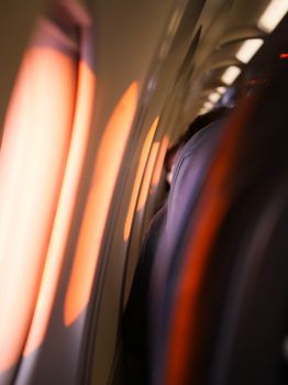 A warm, serene view of sunlight casting through airplane windows onto seats during flight.