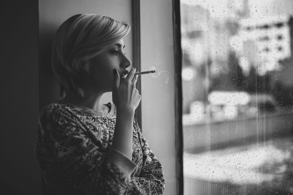 smoking cigarette out window Melancholic woman smoking cigarette near window during rain · Free Stock  Photo