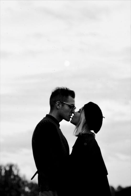 Man and Woman Kissing Grayscale Photo