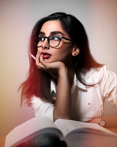 Dreamy woman with book and pencil