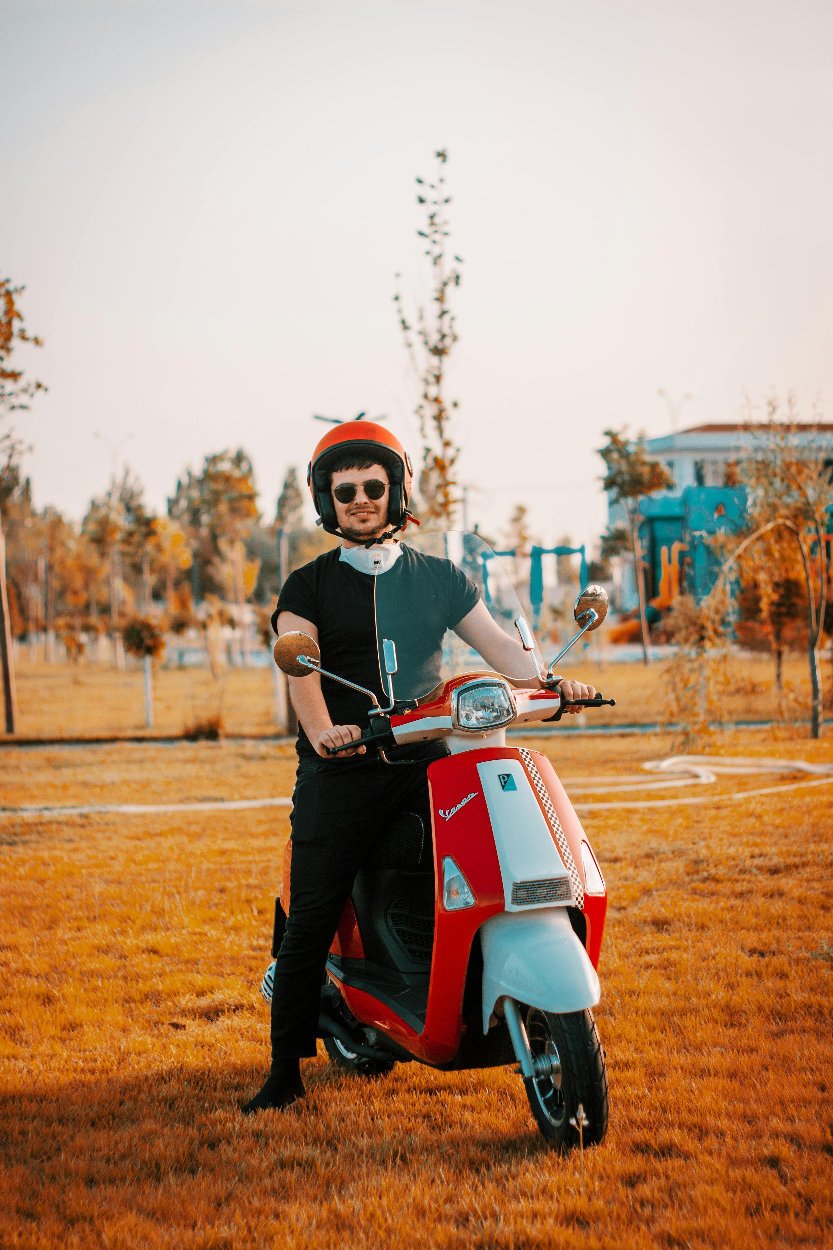 a young woman poses on a vespa motorbike