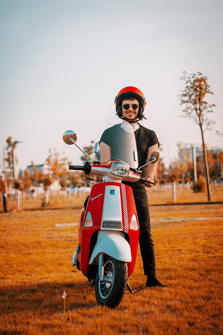 Man In Black Shirt And Helmet Shirt Riding Red Motor Scooter