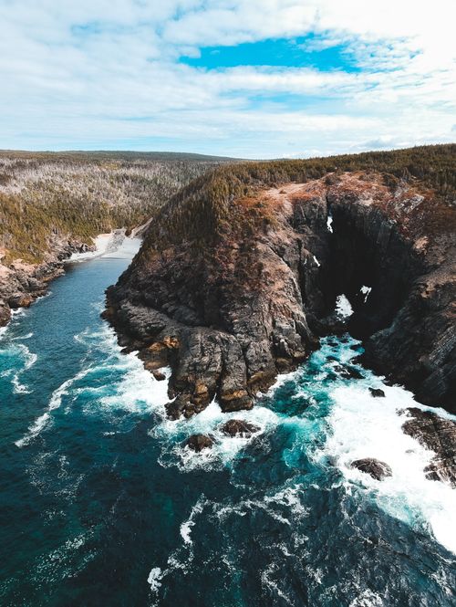 Free Scenic view of rapid river with clean waters flowing along small cave and grassy shores on clear day Stock Photo