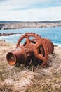 Metal rusted machinery detail left on grassy seashore