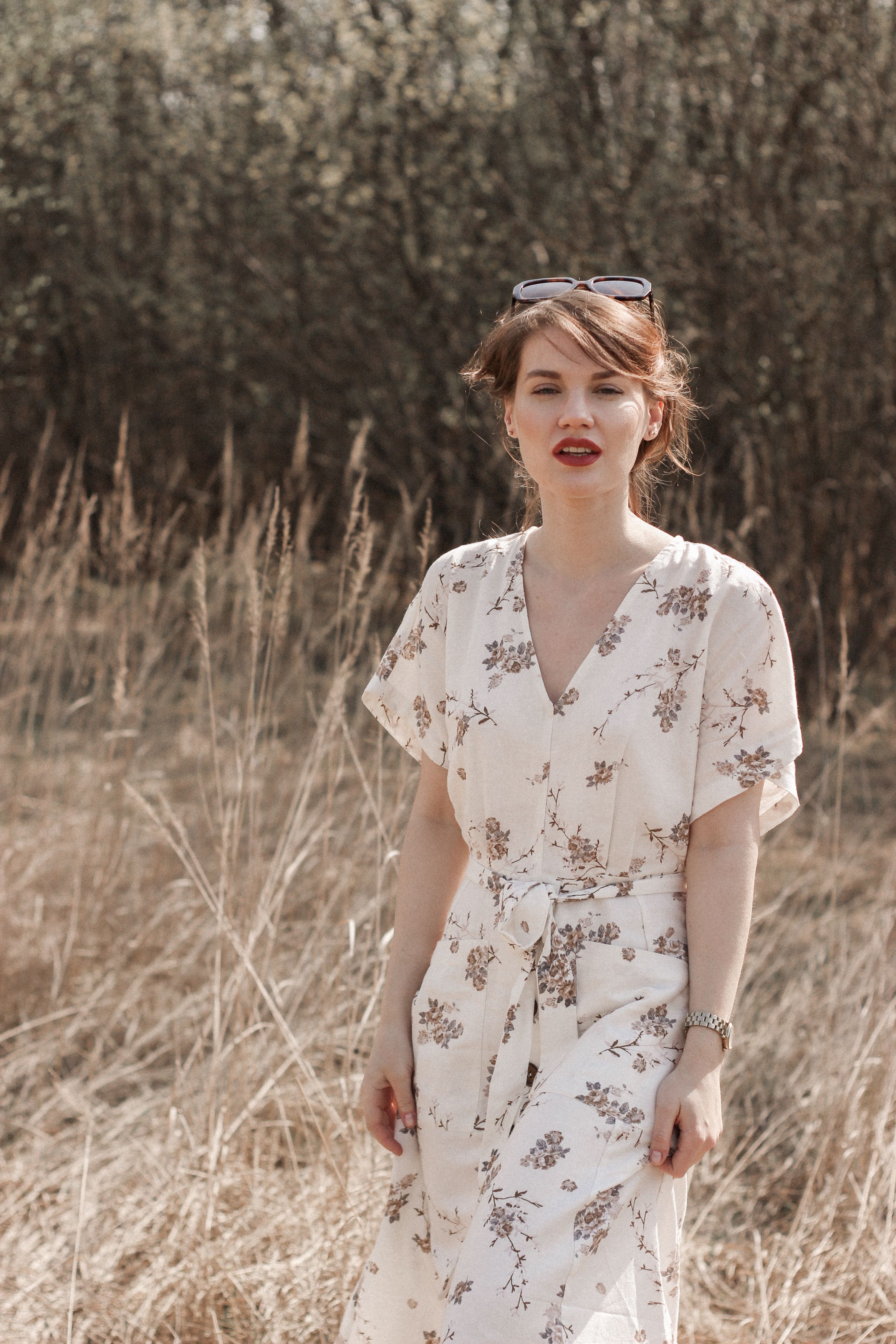 A Woman in White Floral Dress Standing on Brown Grass · Free Stock Photo