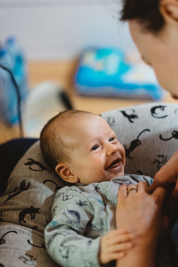Baby giggling while being held by a caregiver