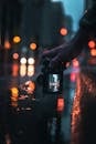 Person Holding Black Dslr Camera Taking Photo of City Lights during Night Time