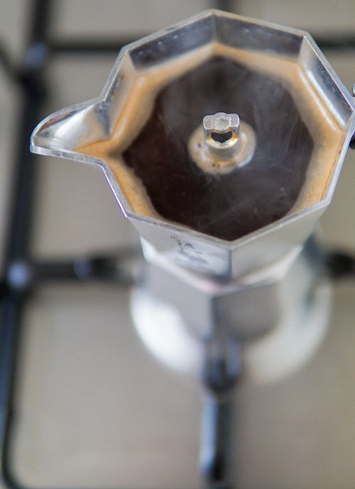 Free From above of fresh brewed coffee in old fashioned moka pot placed on gas stove in kitchen Stock Photo