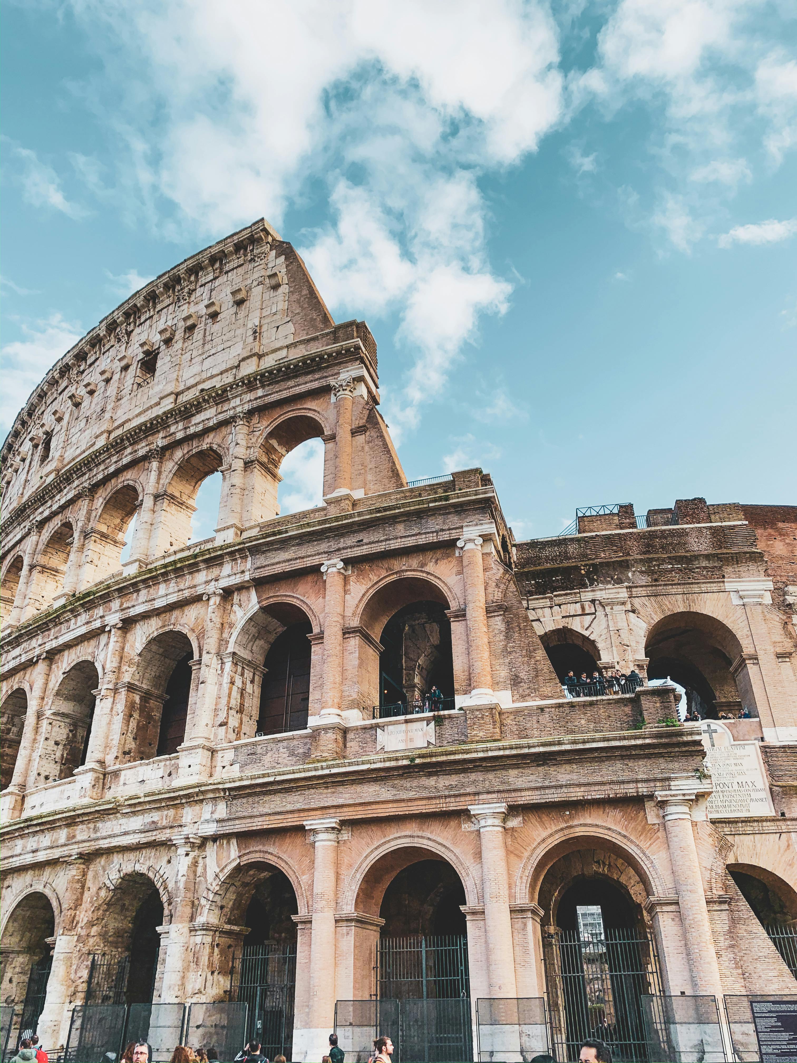 Free A stunning view of Rome's iconic Colosseum under a clear blue sky. Stock Photo